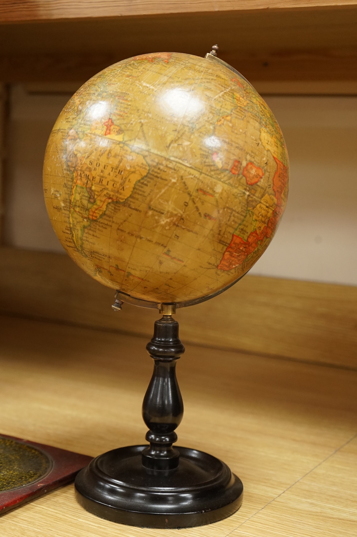 A Geographica 8 inch globe on a turned ebonised wood stand, 39cm high, together with a Chinese ‘Luopan’ compass, for use in feng shui practice.